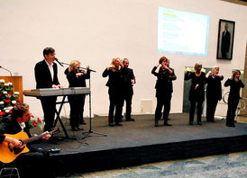 Der Kölner Gebärdenchor St. Georg wird von Peter Worms und einem Musiker begleitet (© Till Muellenmeister)