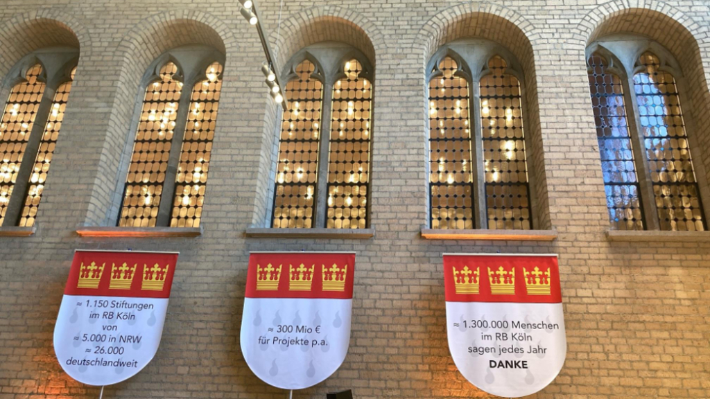 drei städtische, beschriftete Fahnen mit Kölner Wappen in der Piazzetta des Historischen Rathauses zu Köln