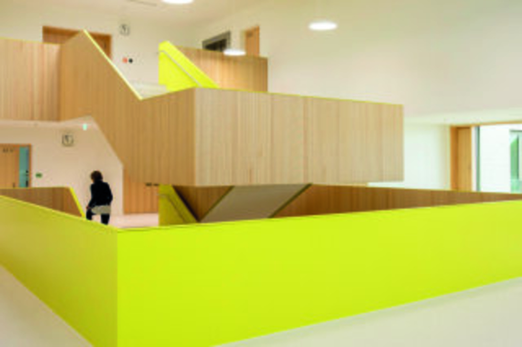 Großzügiges Treppenhaus mit viel Holz und lindgrüner Farbe, Link auf Schulbauten