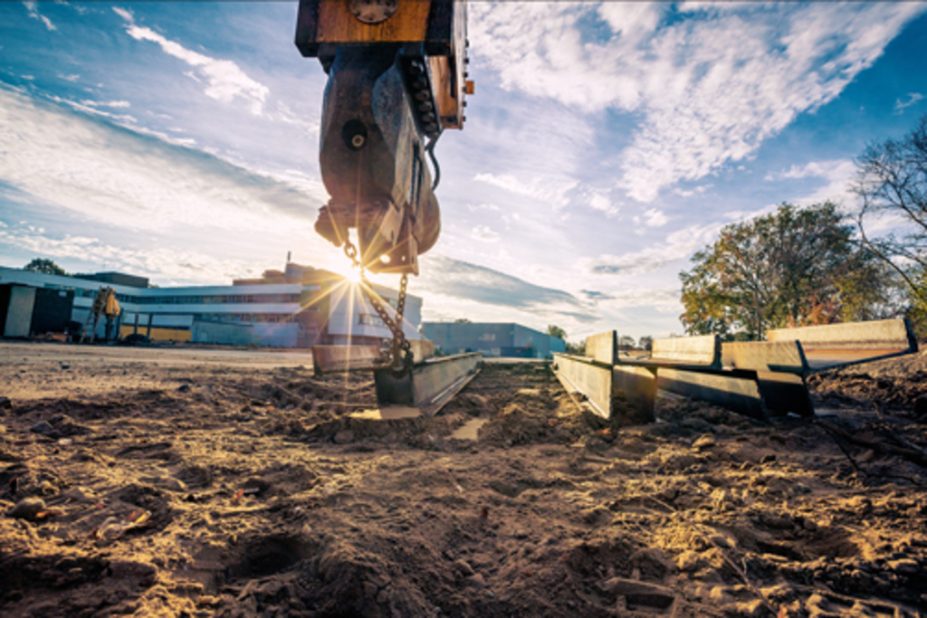 Im Vordergrund das Baufeld, im Hintergrund der alte Schulbau