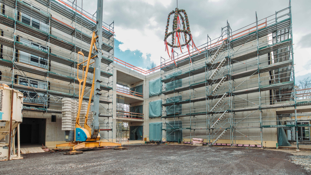 Der Richtkranz wird über dem Rohbau hochgezogen.