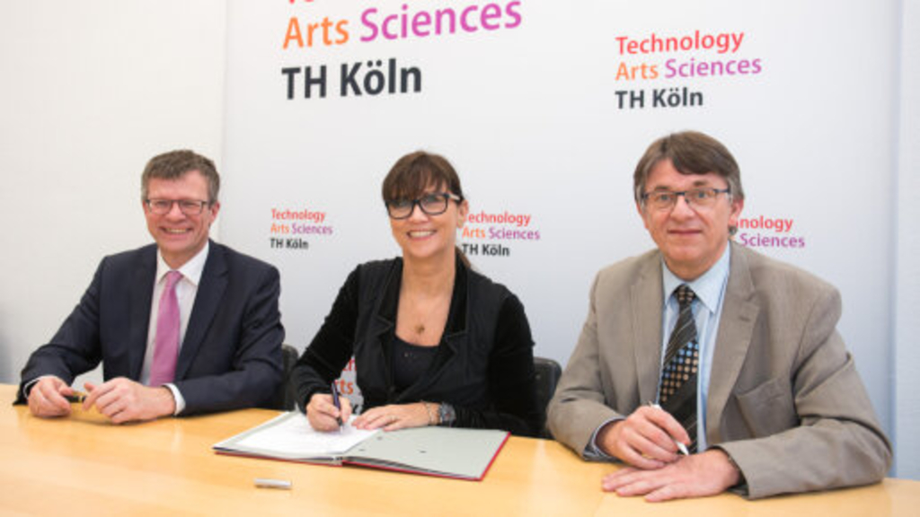 Prof. Dr. Klaus Becker, geschäftsführender Vizepräsident der TH Köln, Petra Rinnenburger, geschäftsführende Betriebsleiterin der Gebäudewirtschaft der Stadt Köln, und Prof. Dr. Jürgen Danielzik von der Fakultät für Bauingenieurwesen und Umwelttechnik unterzeichnen den Vertrag., Link auf Forschung und Wettbewerb - Stadt Köln