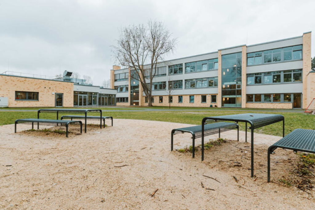 Pausenplätze in der grünen Außenanlage mit Blick auf die Mensa und den Erweiterungsneubau, Link auf Kölner Schulen - Stadt Köln