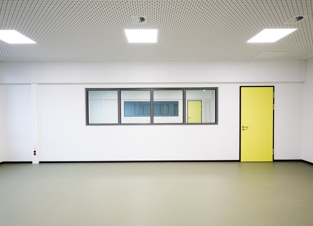 Leerer Unterrichtsraum mit Fenstern und Verbindungstüren zu den dahinterliegenden Räumen