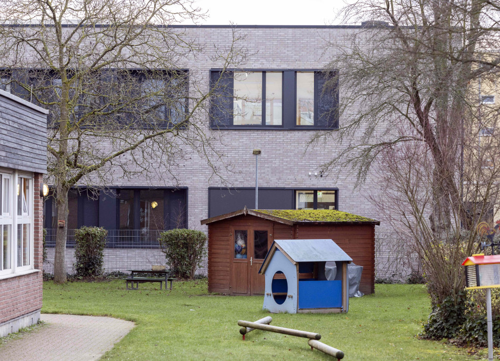 Der verklinkerte Erweiterungsbau fügt sich harmonisch in die Umgebung mit den Grünflächen und Spielgeräten in der Außenanlage ein.
