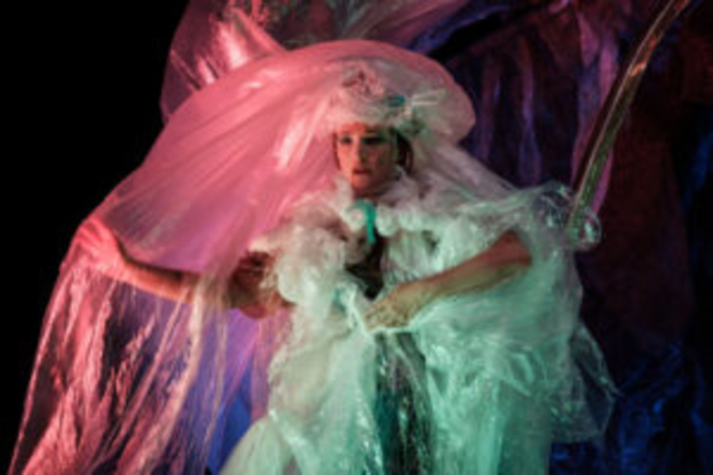 Schauspielerin auf der Bühne in einem Kostüm aus bunter Folie