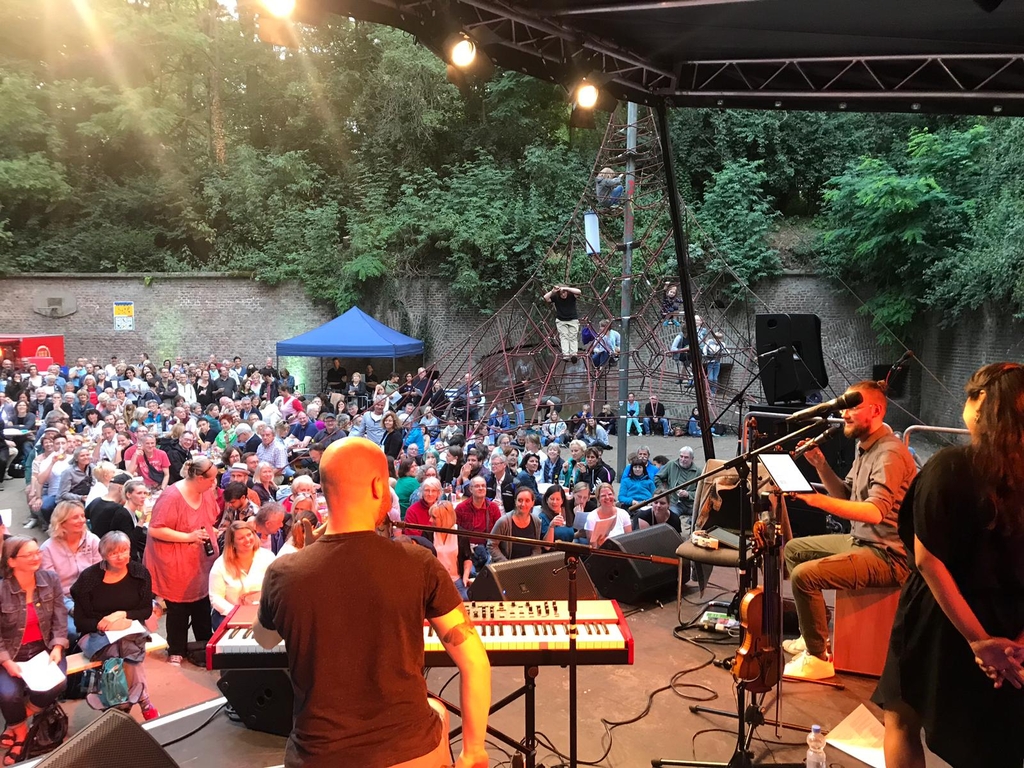 Eine Bühne mit Musiker*innen mit Blick ins Publikum