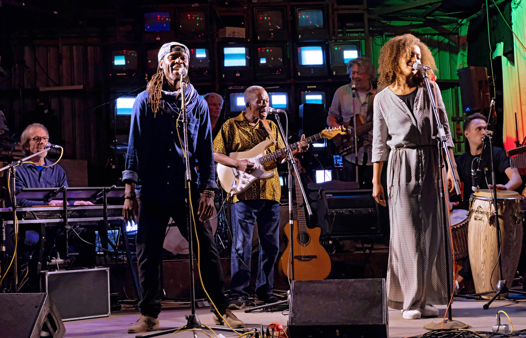 Eine Sängerin auf der Bühne, im Hintergrund Musiker*innen