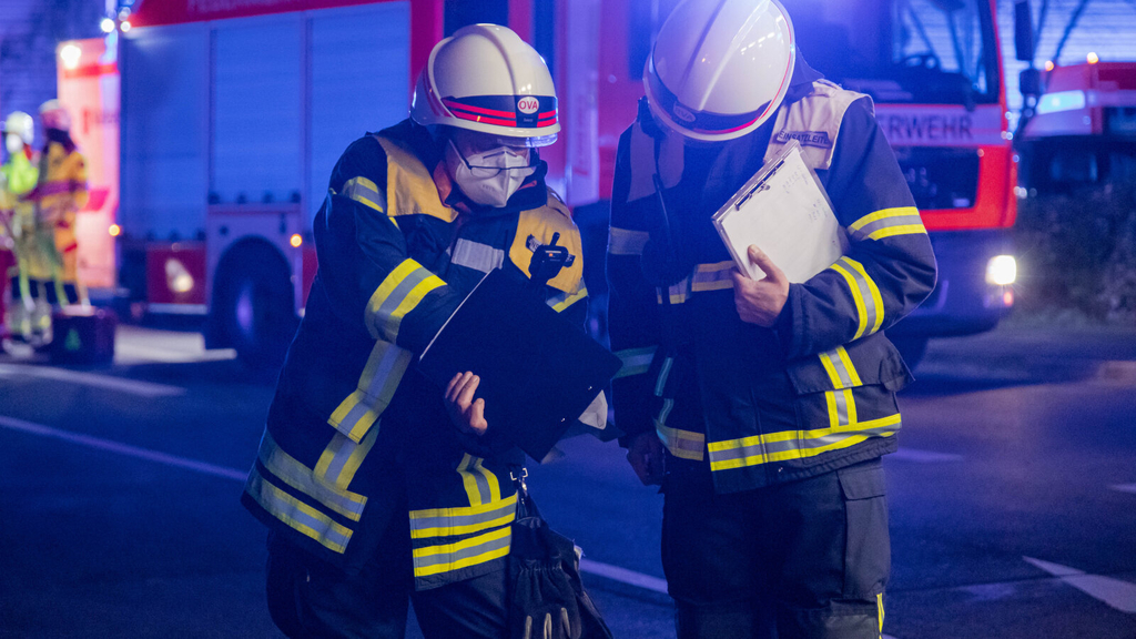 Zwei Einsatzleiter, jeweils aus dem gehobenen und höheren Dienst, beraten sich., Link auf Ausbildung zum*zur Brandoberinspektor*in