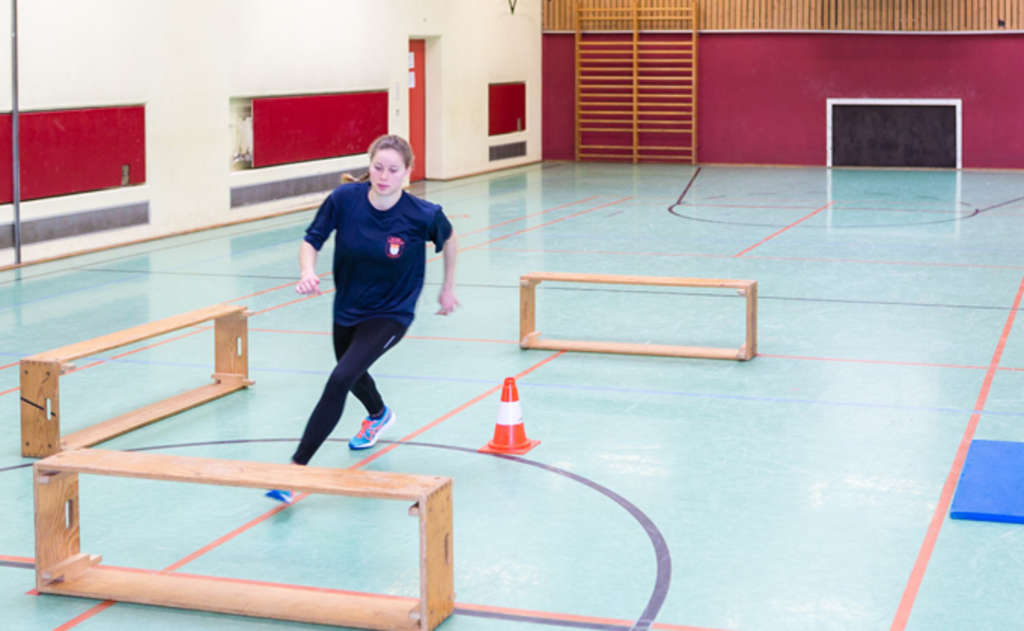 Frau durchläuft einen Hindernisparcours.