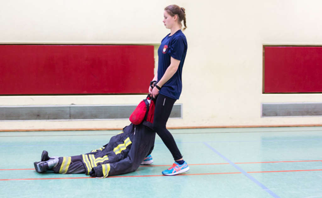 Frau zieht eine Übungspuppe. 