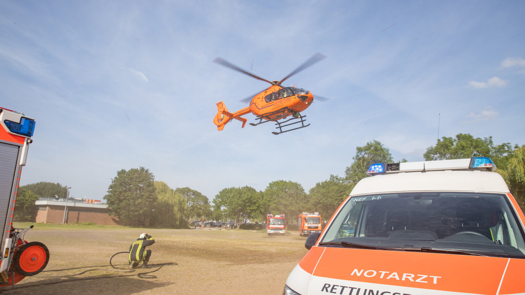 Christoph 3 im Landeanflug. Im Vordergrund steht ein Notarztwagen.