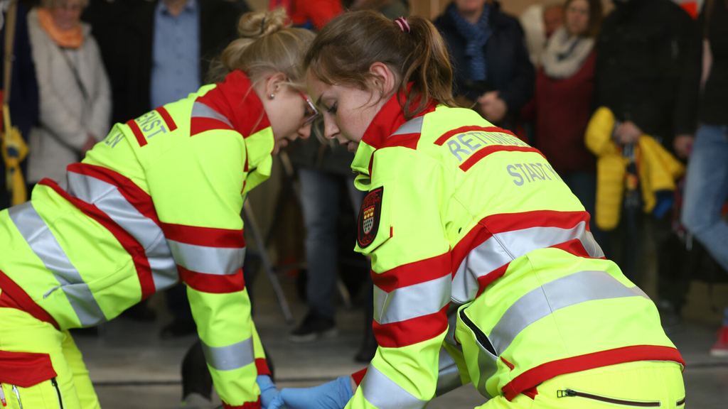 Zwei Notfallsanitäterinnen demonstrieren bei einer Übung die Schritte einer Herzdruckmassage.