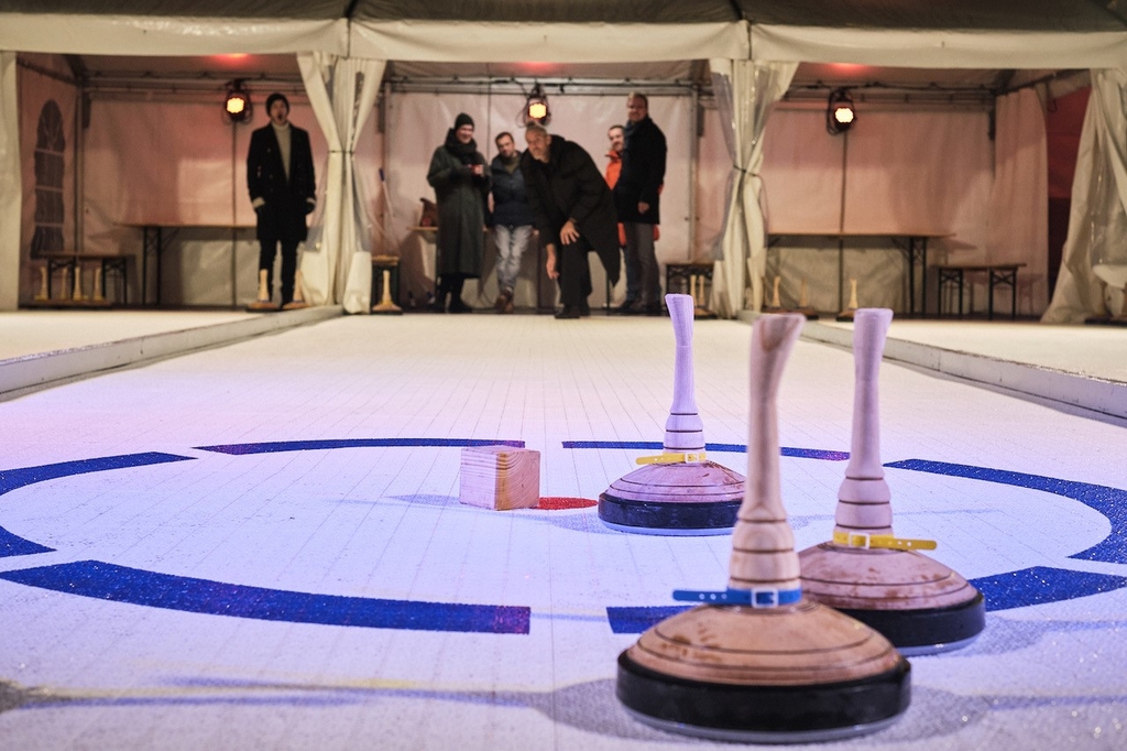 Eisstockschießen auf dem Ebertplatz mit einer Personengruppe im Hintergrund