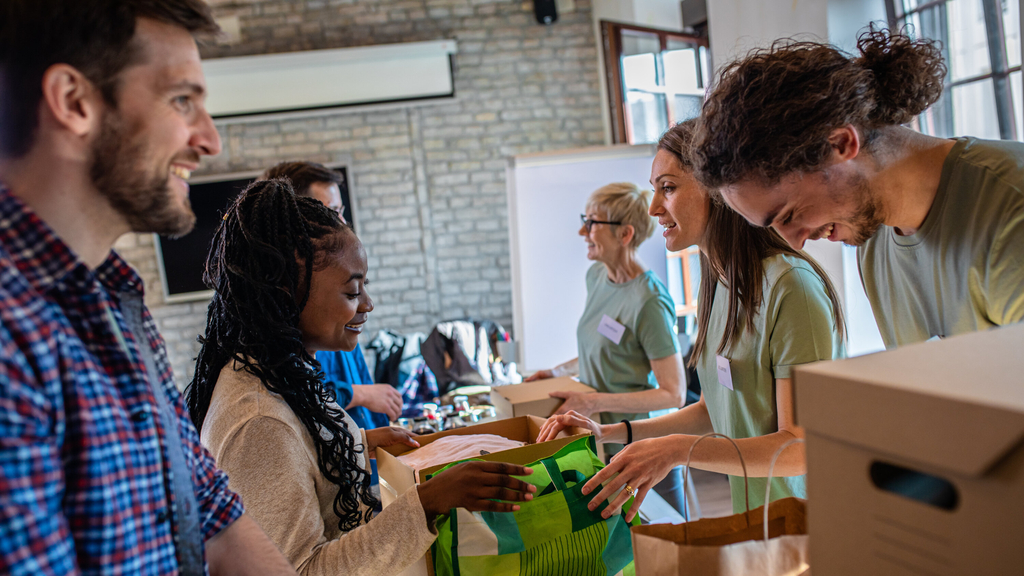 Frewiliige Helfer*innen packen Kisten, Link auf Ehrenamtsbörse digital - Stadt Köln