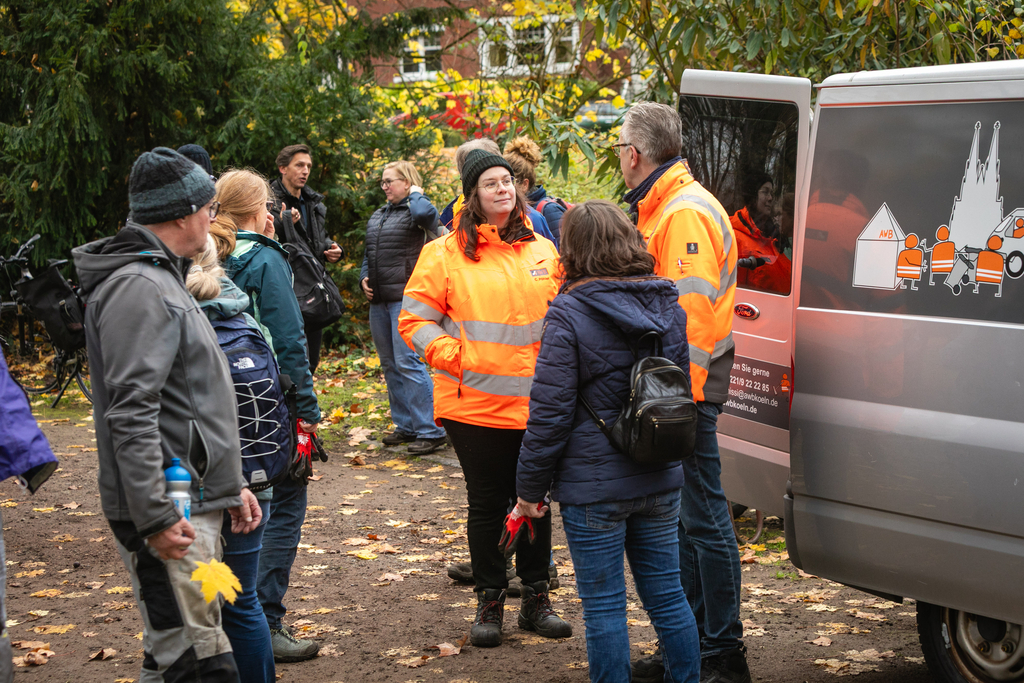 Personengruppe im kurzen Austausch nach der Laubsammelaktion.
