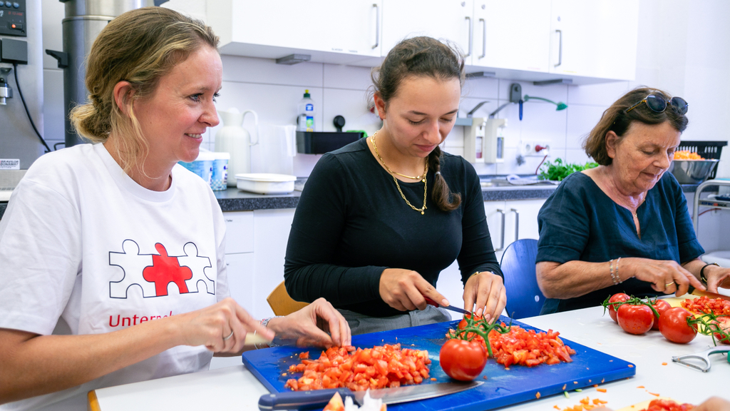 Mitarbeitende der Firma Brügelmann engagieren sich beim Mittagstisch der Carlskirche, Link auf Warum engagieren? - Stadt Köln