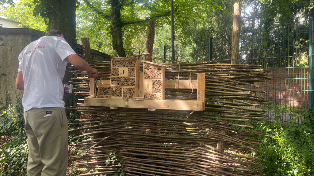 Mitarbeiter der PPM Agentur engagiert sich auf dem Außengelände der Diakonie Michaelshoven