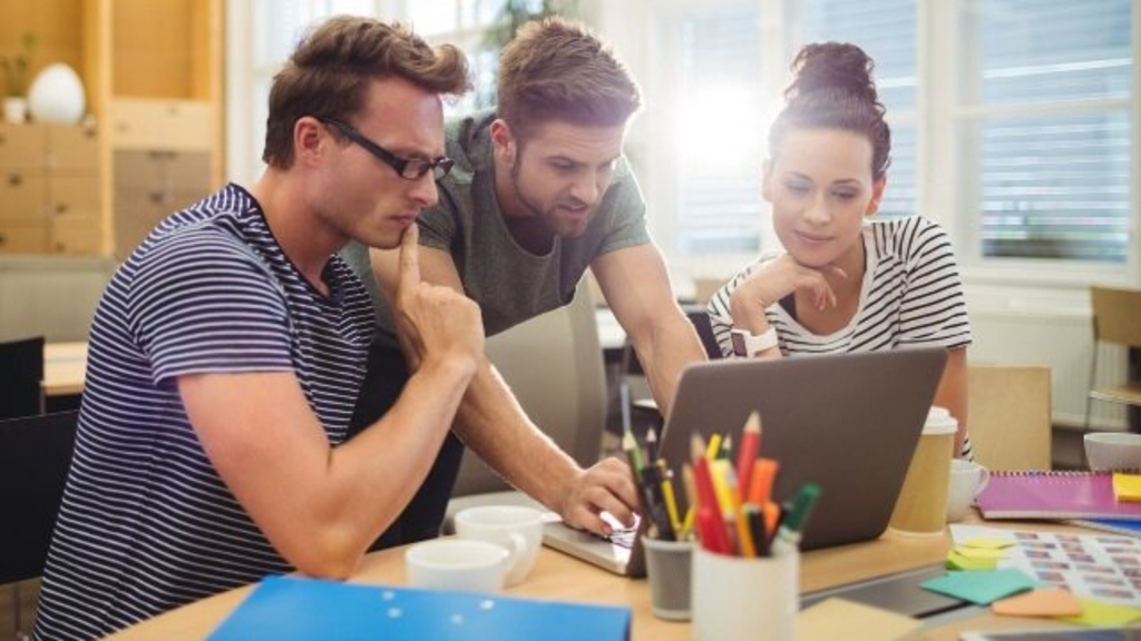 Zwei junge Unternehmer und eine junge Unternehmerin arbeiten kreativ zusammen