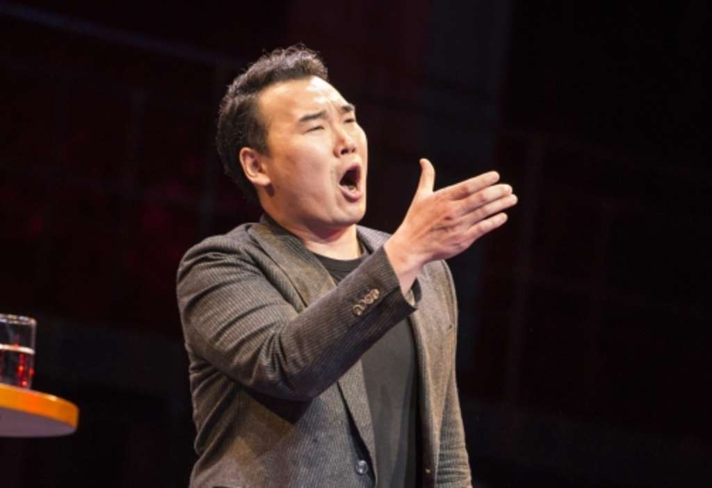 Young Woo Kim steht auf einer Bühne und singt