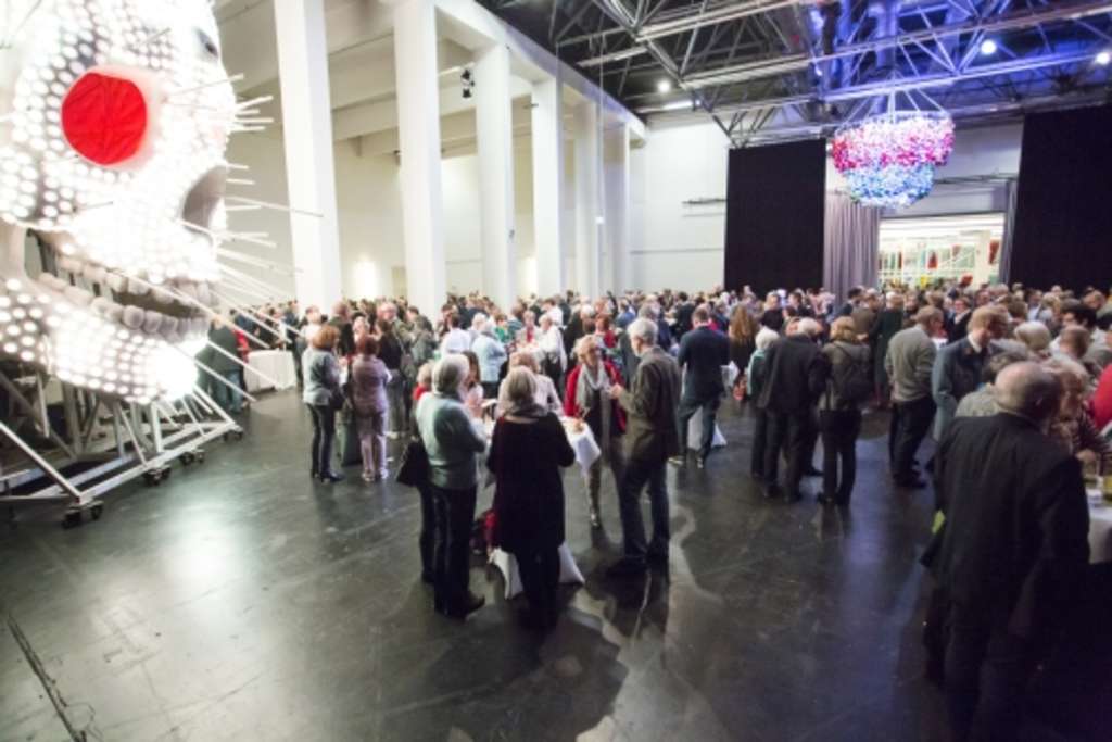 Ein großes Publikum steht in einer großen Halle