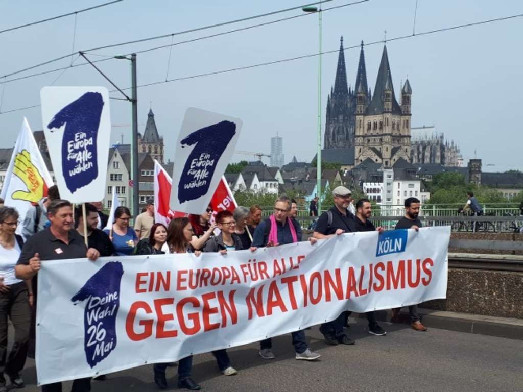 Demonstrierende gehen mit einem großen Banner "Ein Europa für alle Gegen Nationalismus" über die Severinsbrücke. 