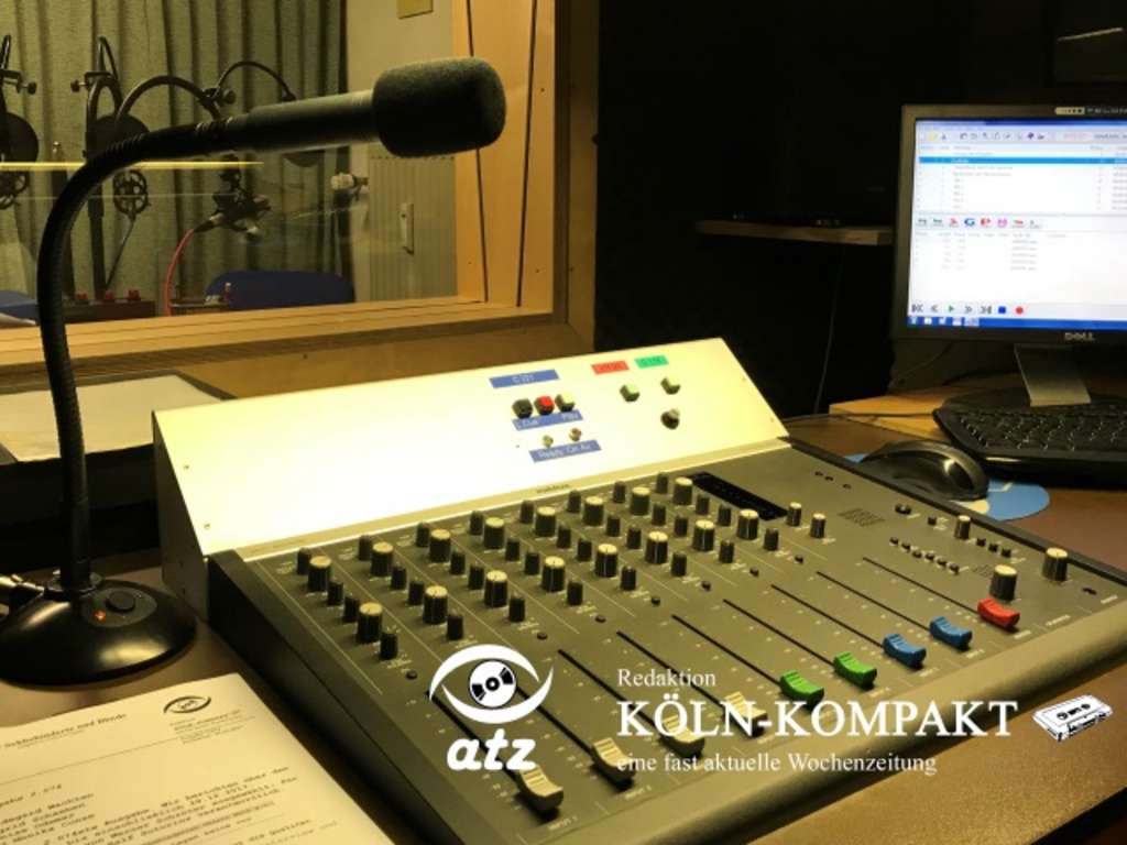 Tonstudio von der Redaktion Köln Kompakt, mit Mischpult, Mikrofon und Computer. Hinter einer Scheibe das Aufnahmestudio mit verschiednen Mikrofonen.