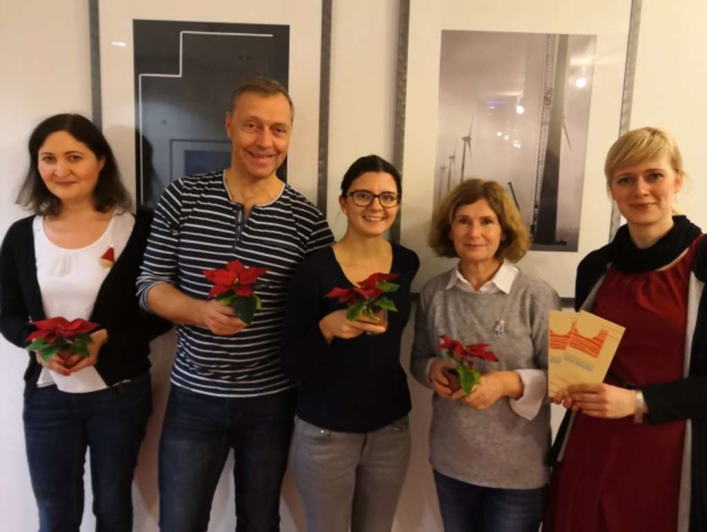 Fünf Mitarbeitende der Stadt nach ihrem ehrenamtlichen Einsatz stehen nebeneinander und halten jeweils eine Blume in den Händen.