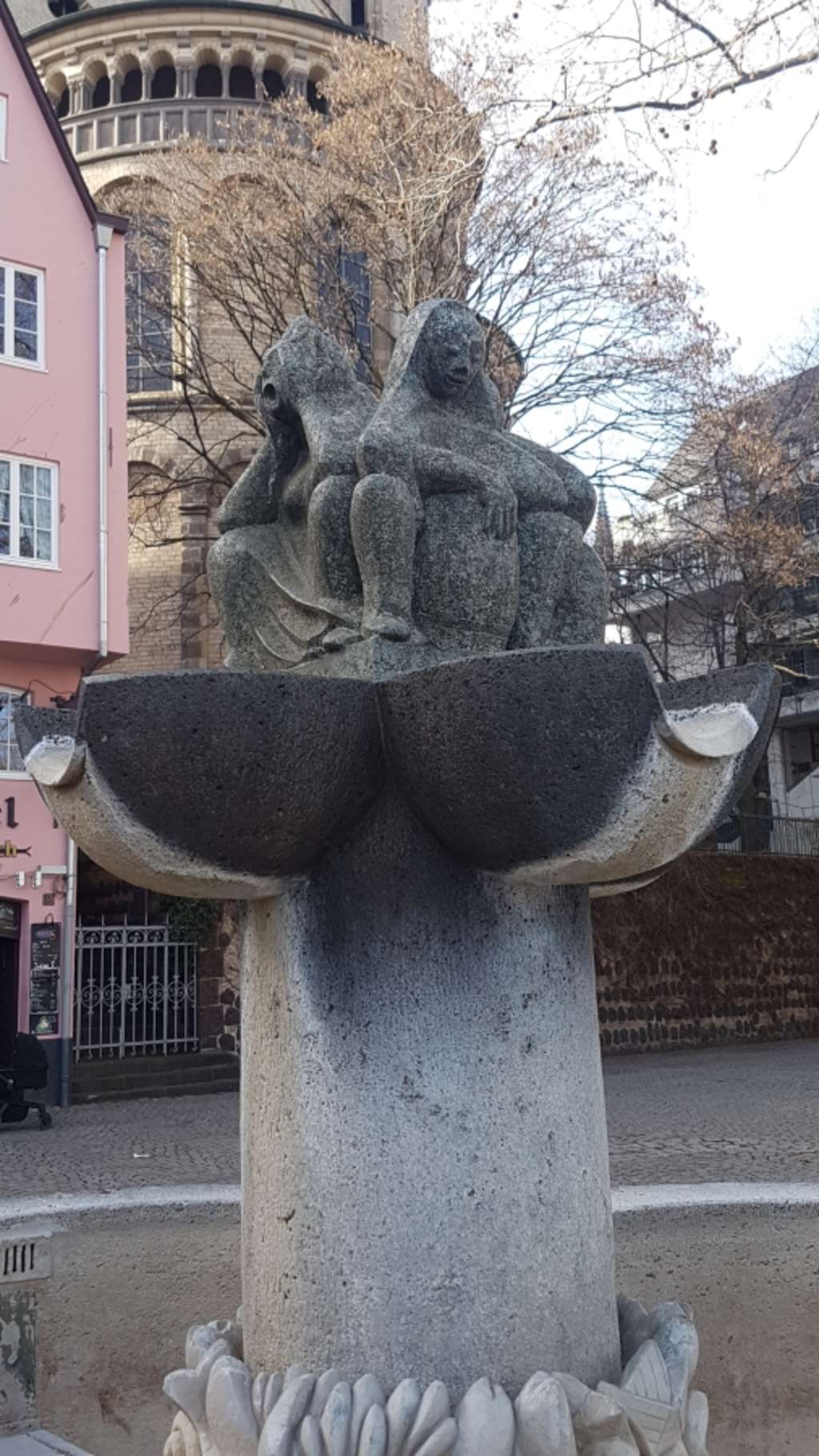 Foto des Kölner Fischweiberbrunnens, Skulptur von mehreren Frauen, die Rücken an Rücken sitzen, unter Ihnen das Brunnenwasser