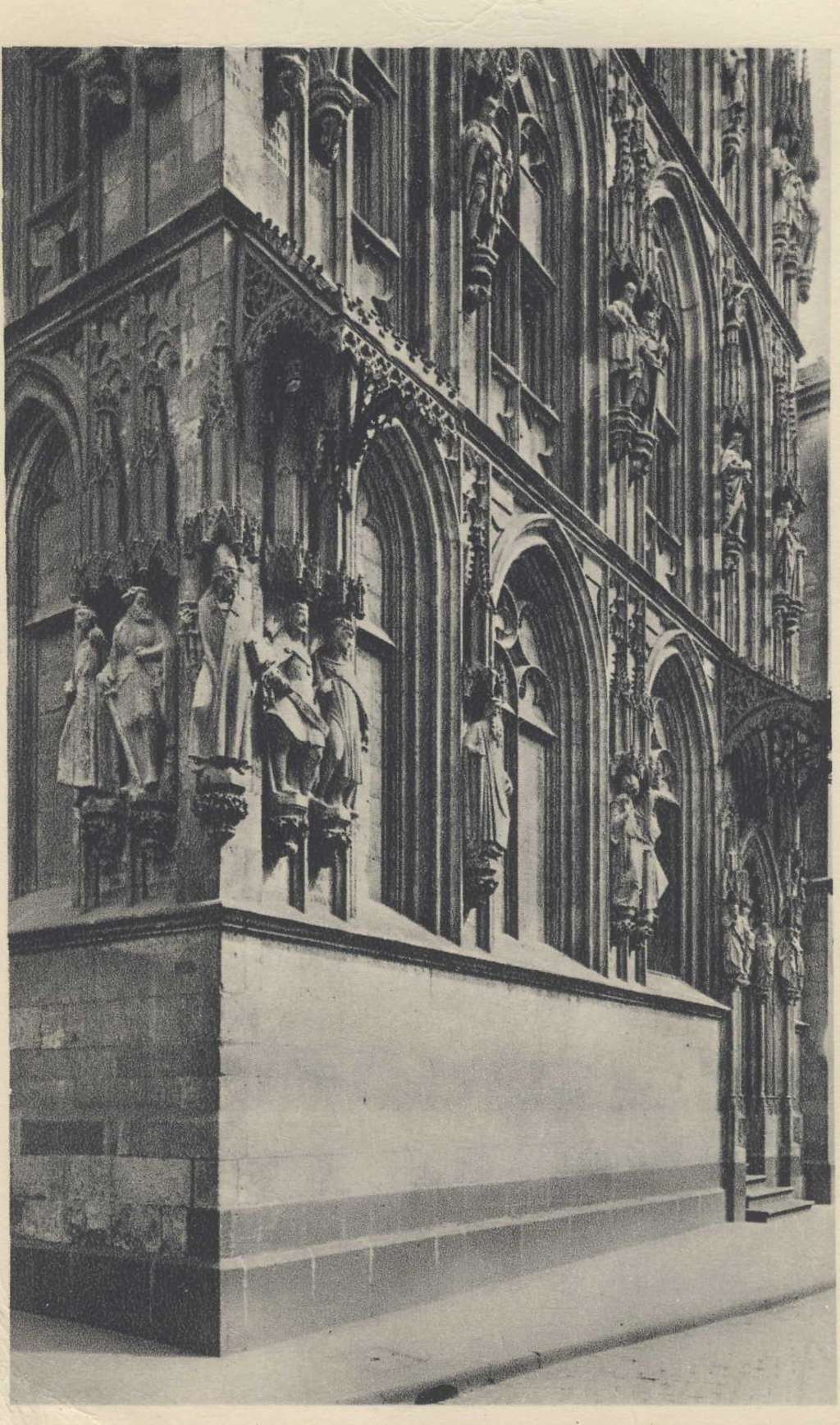 Altes Schwarzweißfoto dass einen Ausschnitt der Fassade des Kölner Ratsturms mit seinen vielfältigen Steinskulpturen zeigt