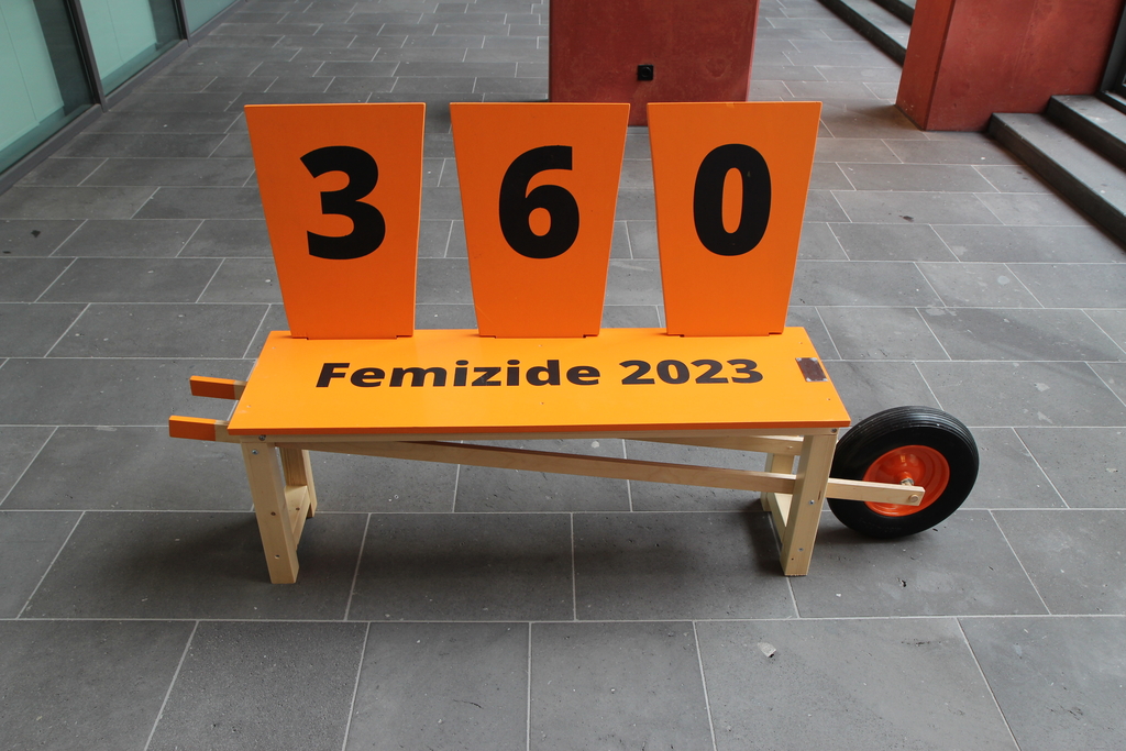 Die orangene Bank mit der Aufschrift "360 Femizide im Jahr 2023" wird im Stadthaus in Deutz präsentiert 