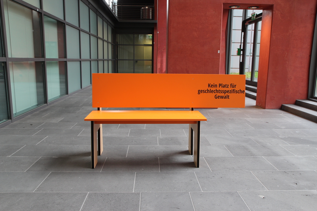 Die orangene Bank mit der Aufschrift "Kein Platz für geschlechtsspezifische Gewalt" steht im Stadthaus in Deutz