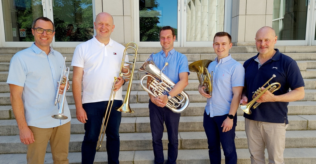 Auf dem Foto sind die fünf Mitglider des Brass Quintents zusammen mit ihren Instrumenten abgebildet.
