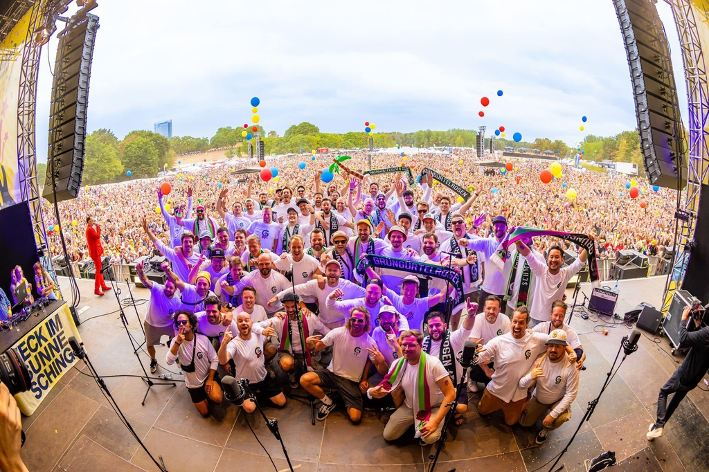 Foto der Grüngürtelrosen auf einer Bühne, im Hintergrund sieht man das Publikum