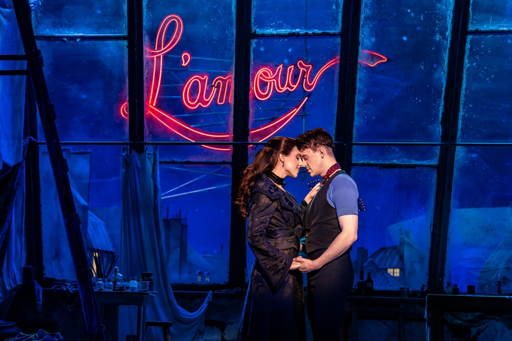 Foto von zwei Darsteller*innen des Moulin Rouge, wie sie eng umschlugen gegenüber stehen