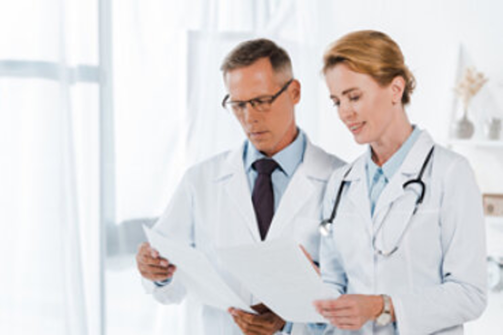 Arzt und Ärztin unterhalten sich , Link auf Migration und Gesundheit - Clearingstelle
