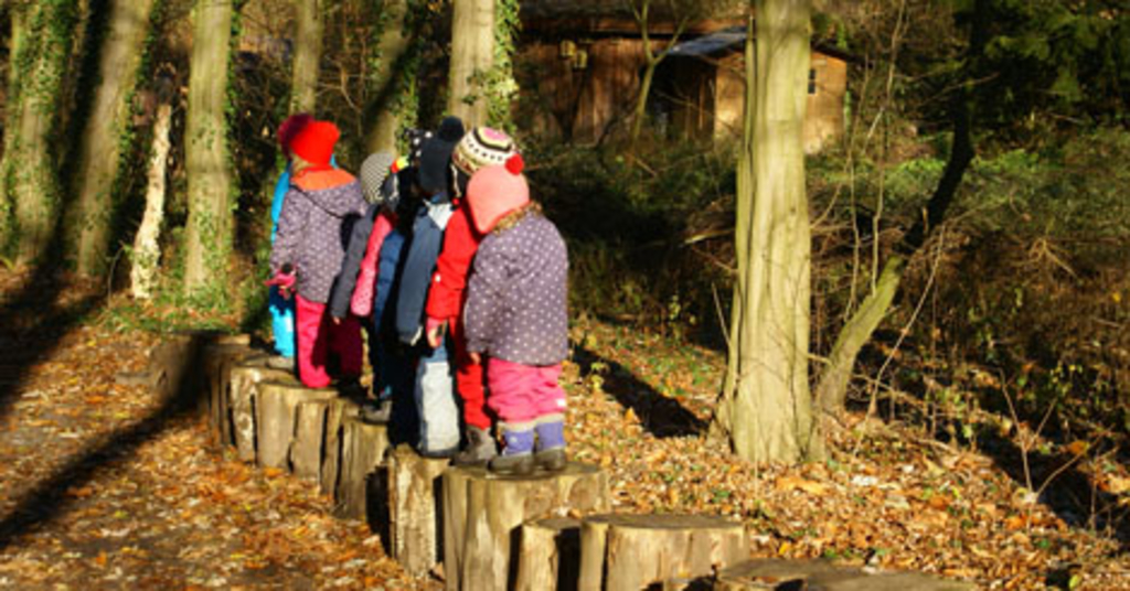 Kinder auf Baumstümpfen