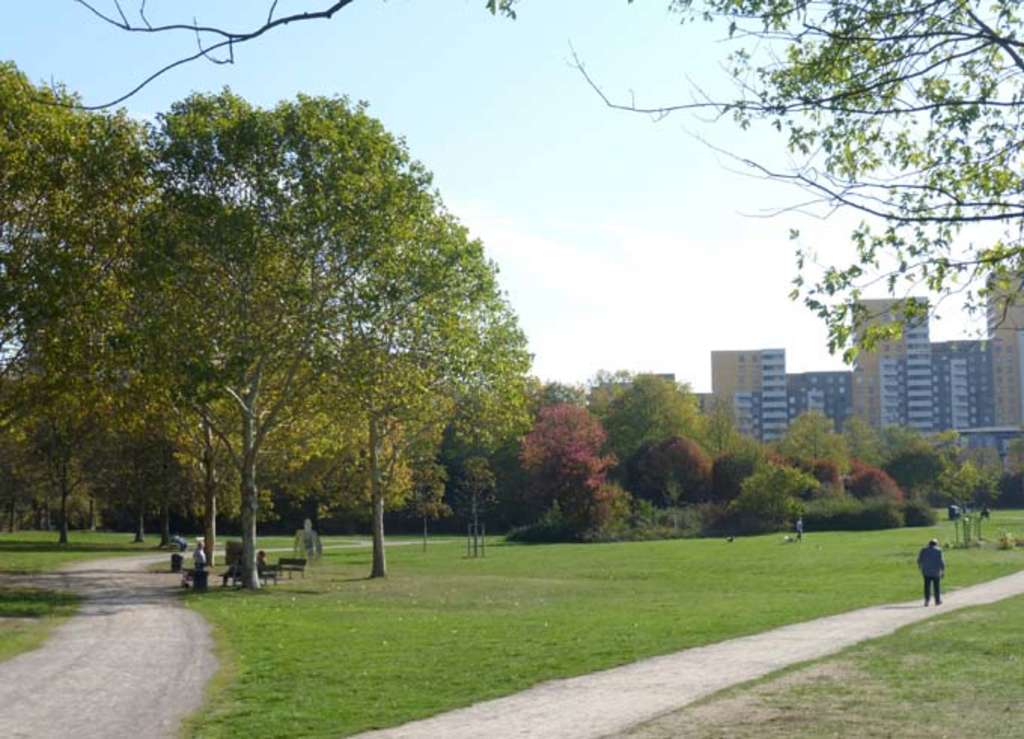 Olof-Palme-Park, Bäume, Wiese und im Hintergrund Hochhäuser