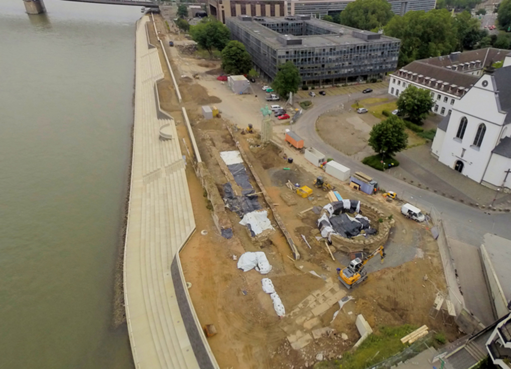 Im Foto links die fertige Ufertreppe und rechts davon die Baustelle des Bauabschnittes Boulevard mit im Vordergrund rechts dem archäologischen Grabungsfeld im Bereich des ehemaligen römischen Kastells.