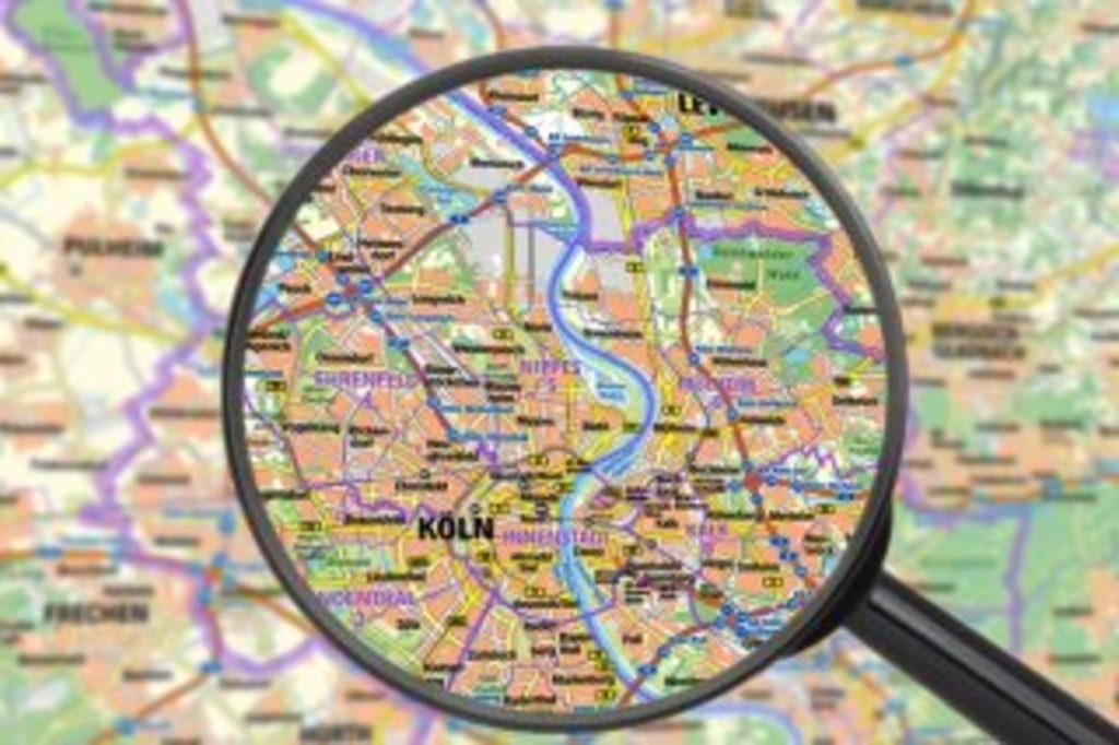 Lupe, auf der man eine Stadtkarte von Köln sieht, Link auf Karten, Kataster und Vermessung