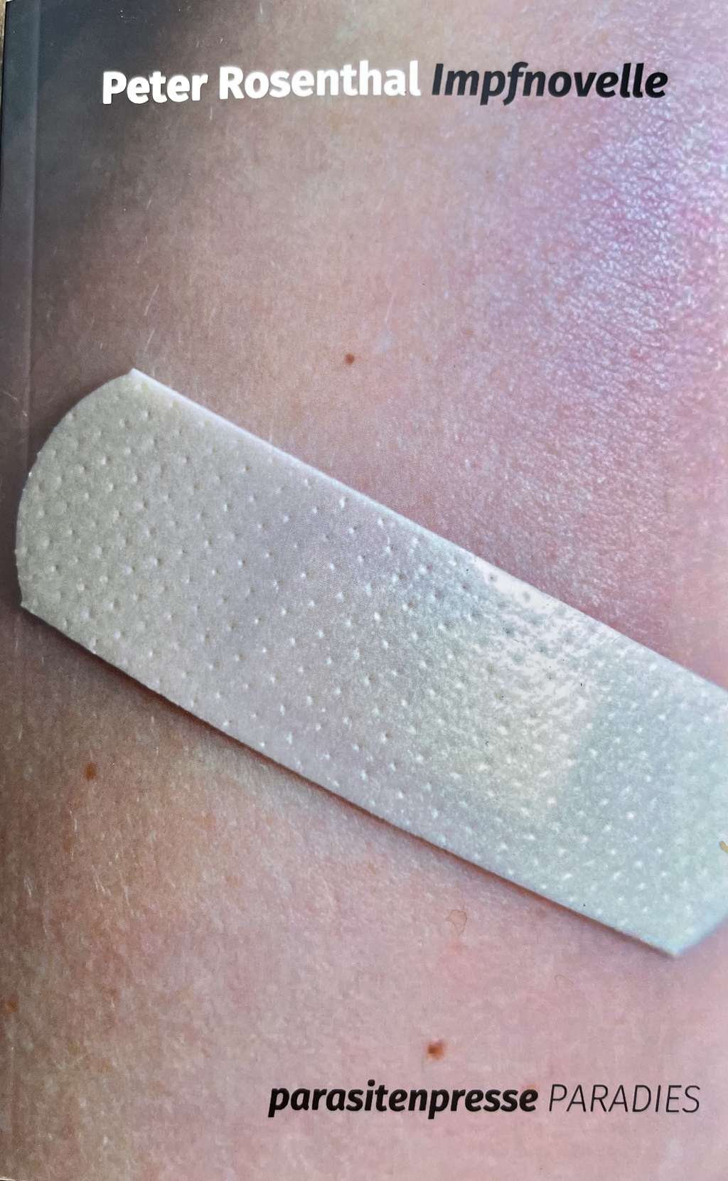 Ein weißes Pflaster auf Haut.