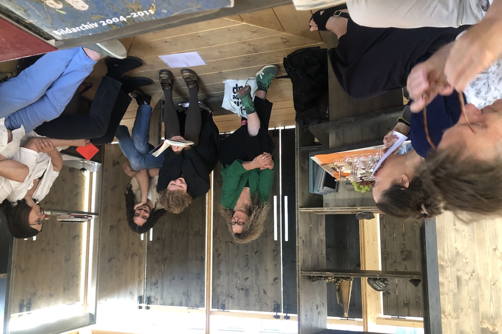 Foto von mehreren Menschen, die im hölzernen Pavillion am Waidmarkt sitzen