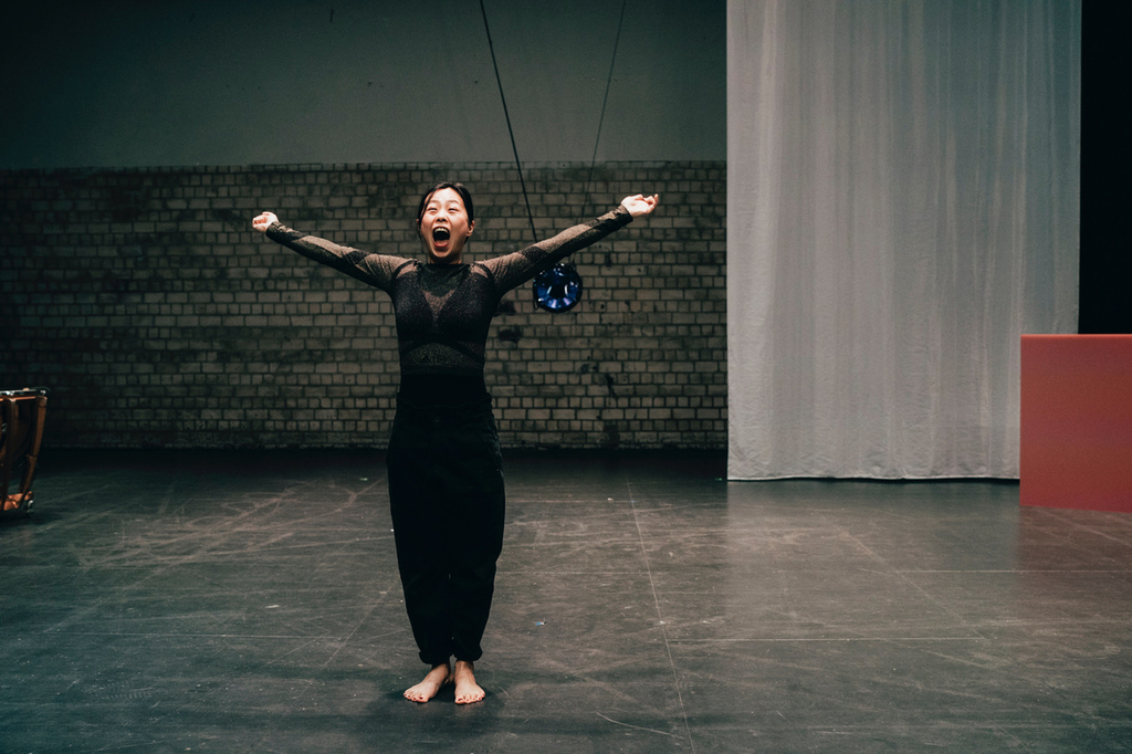 Bild einer Frau, die mit weit ausgestreckten Armen schreit