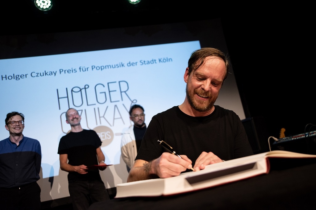 Auch die Mitglieder der Band Von Spar tragen sich in das Gästebuch der Stadt Köln ein