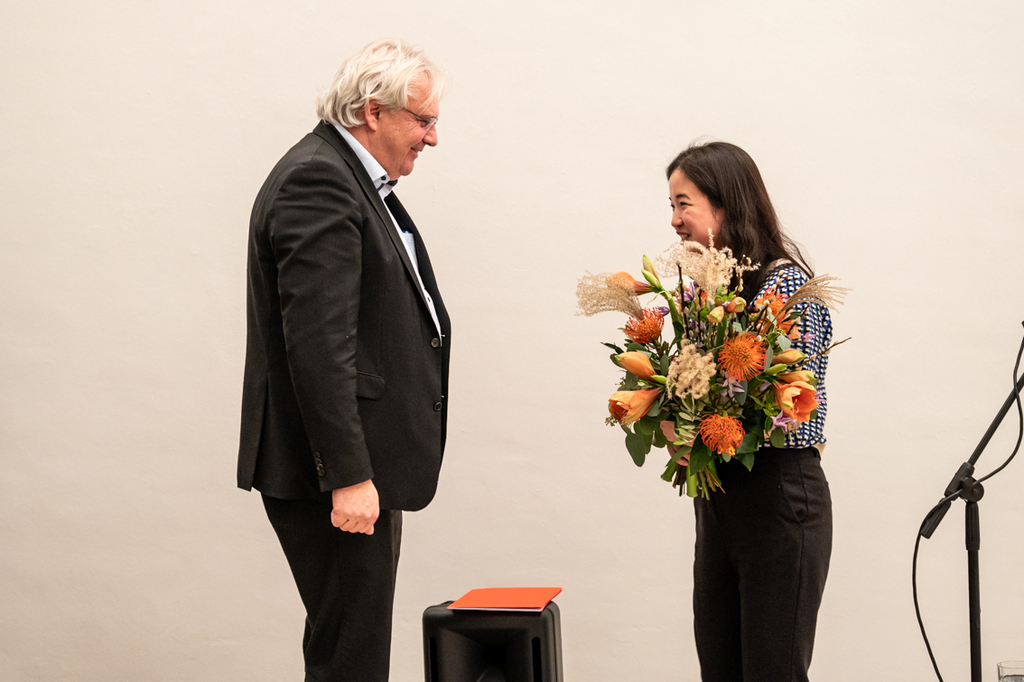 Foto mit Dr. Ralph Elster und Yoora Park mit einem Blumenstrauß in der Hand