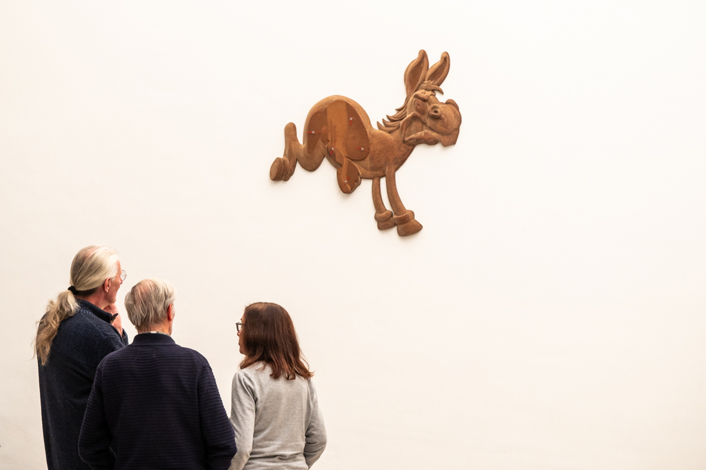 Besuchende beim Betrachten der Eselmotive, die Uhren am Körper tragen