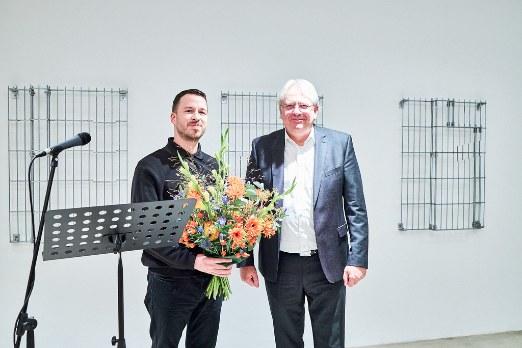 Foto mit Bürgermeister Dr. Ralph Elster und Preisträger Mathias Weinfurter mit einem Blumenstrauß in der Hand