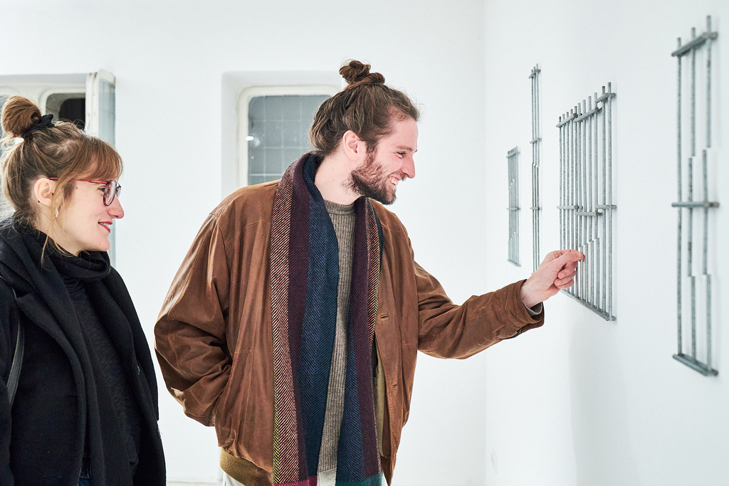 Foto von zwei Besucher*innen der Ausstellung vor den Werken