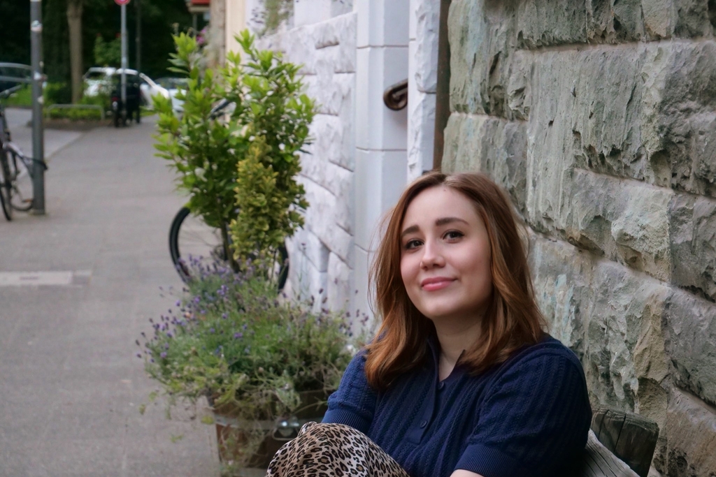 Jorik Bergman mit einer Querflöte in der Hand im Schneidersitz sitzend, Link auf Rolf-Dieter-Brinkmann-Stipendium für Literatur 2025