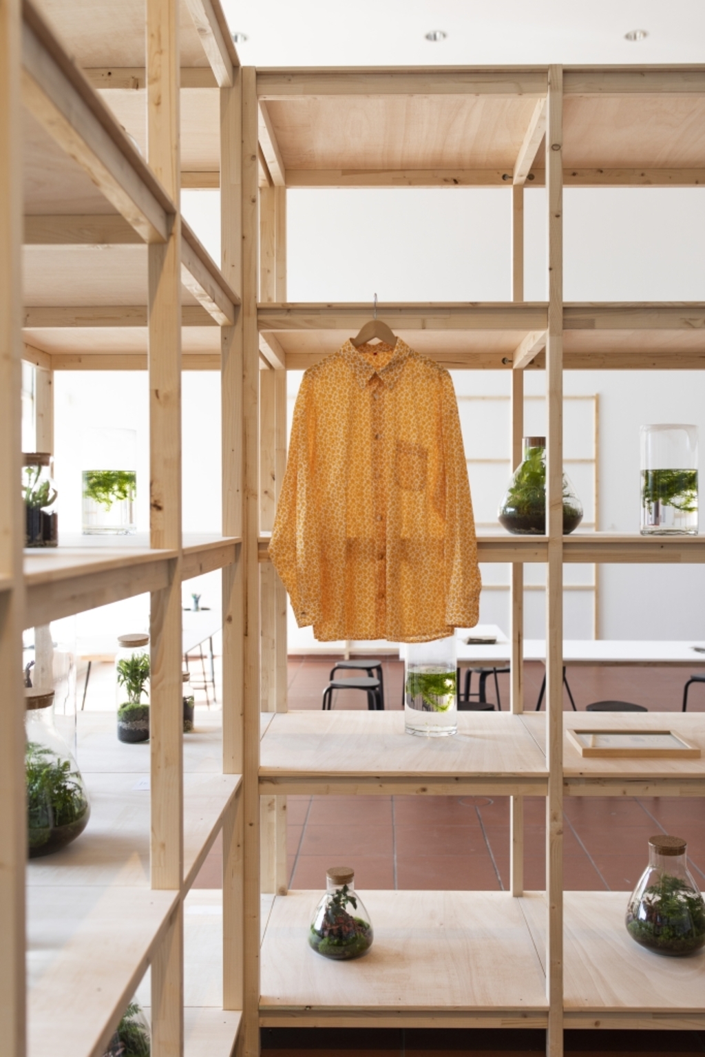 Gelbe Kostümbluse in einer Installation der Ausstellung Grüne Modern, Regal mit Pflanzentöpfen